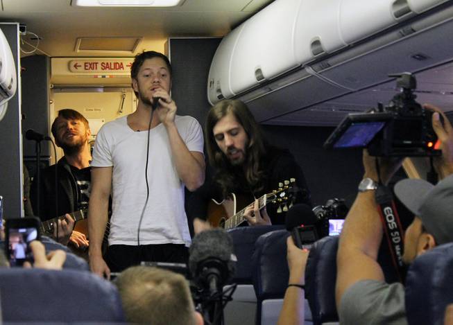 Members of Imagine Dragons, from left, Ben McKee, Dan Reynolds and Wayne Sermon are shown during a "Destination Dragons" in-flight performance on Tuesday, Feb. 24, 2015.