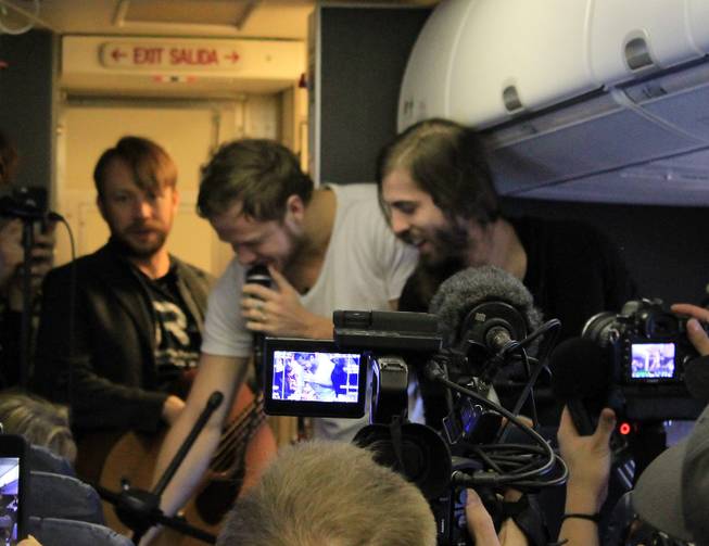 Members of Imagine Dragons, from left, Ben McKee, Dan Reynolds and Wayne Sermon, are shown during a "Destination Dragons" in-flight performance on Tuesday, Feb. 24, 2015.