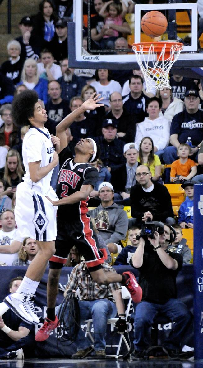 UNLV's Patrick McCaw puts up a reverse layup as Utah State's Jalen Moore defends during an NCAA college basketball game, Tuesday, Feb. 24, 2015, in Logan, Utah. 