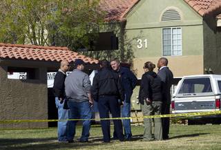 Investigators confer in a common area near the scene of an officer-involved shooting Wednesday, Feb. 25, 2015, at the Eagle Trace apartment complex near Nellis Air Force Base.