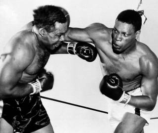Nino Valdes, right, of Cuba, jolts the veteran Archie Moore with an overhand right to the head in the third round of their scheduled 15-round heavyweight fight at Cashman Field May 2, 1955.