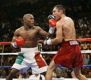 Floyd Mayweather Jr., left, lands a left on Oscar De La Hoya during the twelfth round of their WBC super welterweight world championship boxing match on Saturday, May 5, 2007, at the MGM Grand Garden Arena  in Las Vegas. (AP Photo/Kevork Djansezian)