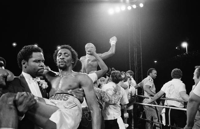 Thomas "Hitman" Hearns is carried from the ring in Las Vegas Monday night, April 15, 1985 as Marvelous Marvin Hagler celebrates his undisputed world middleweight championship.   Hagler knocked out Hearns in the third round of the fight.