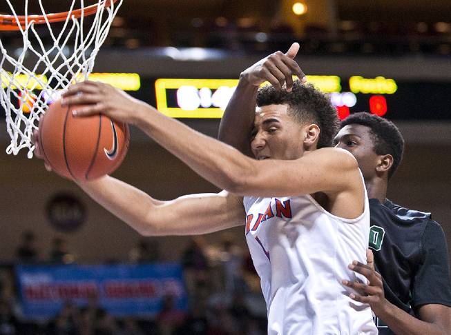 Bishop Gorman's Chase Jeter (4) takes a shot to the head as he drives to the basket over Palo Verde's Jamell Garcia-Williams (35) during the state basketball championship game on Friday, Feb. 27, 2015.