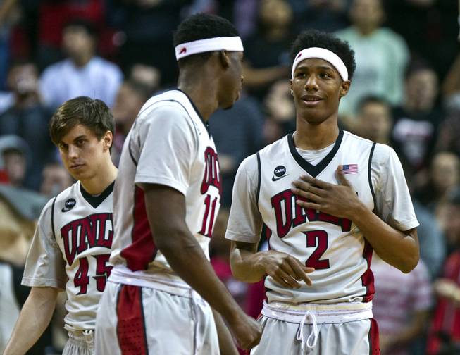 UNLV forward Goodluck Okonoboh, center, looks to teammate Patrick McCaw during a timeout as both are having a strong game versus Wyoming on Saturday, Feb. 28, 2015. 