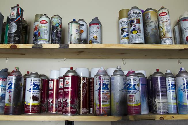 Spray paint cans line shelves in artist Izaac Zevalking's studio Sunday, March 1, 2015, in Summerlin. Zevalking, the artist behind Recycled Propaganda, will be celebrating two years of being with First Friday on March 6.