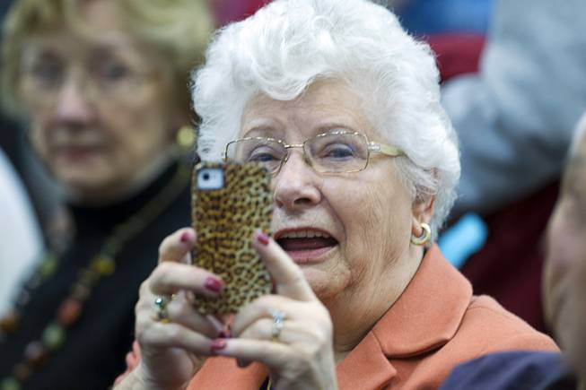 A woman takes a photo while she waits to see former Florida Gov. Jeb Bush responds to a question during question and answer session at the Mountain Shadows Community Center in Las Vegas Monday, March 2, 2015.
