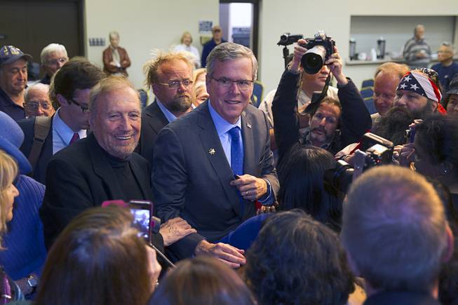 Former Florida Gov. Jeb Bush, center, poses for photos after a question and answer session at the Mountain Shadows Community Center in Las Vegas Monday, March 2, 2015.
