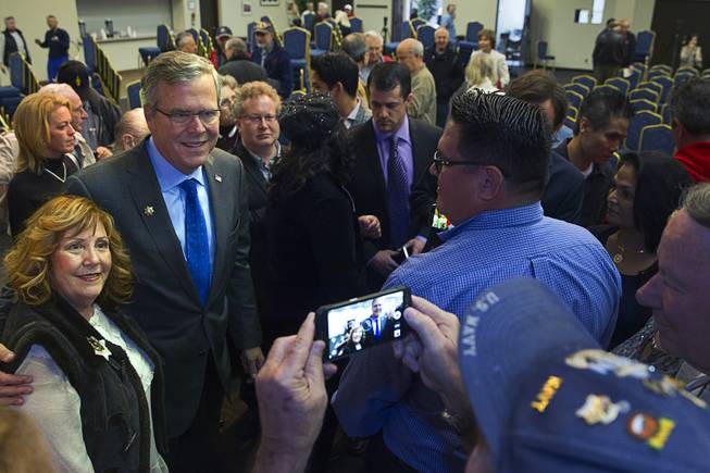 Former Florida Gov. Jeb Bush, center, poses for a photo with Jackie Eastman after a question and answer session at the Mountain Shadows Community Center in Las Vegas Monday, March 2, 2015.