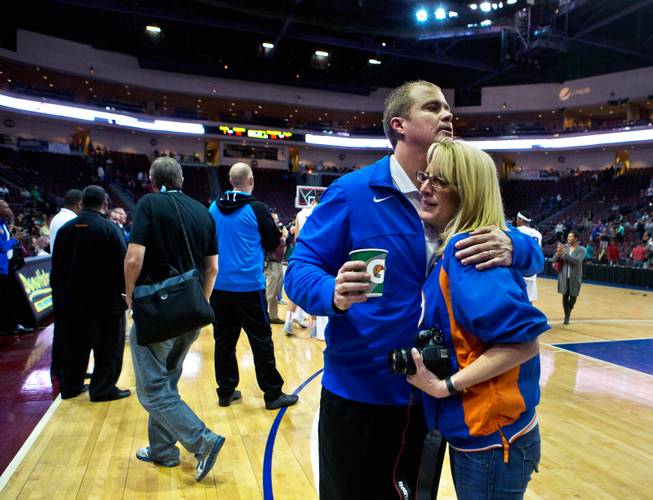 Bishop Gorman head coach Grant Rice receives a hug as his players celebrate their win over Palo Verde behind him during the NIAA Division 1 State Basketball Championships on Friday, February, 27, 2015.