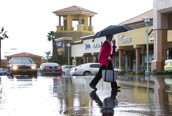 Joean Carlgren keeps dry under her umbrella as she walks though light rain Tuesday, March 3, 2015, in Henderson.