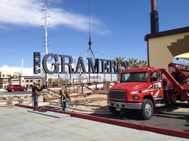 Workers with Nevada Sign prepare to hoist part of a 90-foot sign at the Gramercy mixed-use development Tuesday, March 3, 2015.