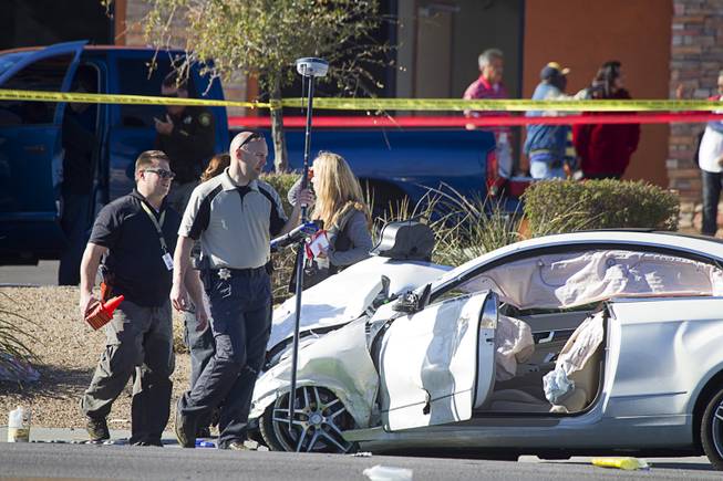 Metro Police investigators walk by a Mercedes-Benz at the scene of a fatal accident on Boulder Highway Thursday March 5, 2015.  The driver of the Mercedes was arrested for DUI, police said. Two women were killed in the early morning accident.
