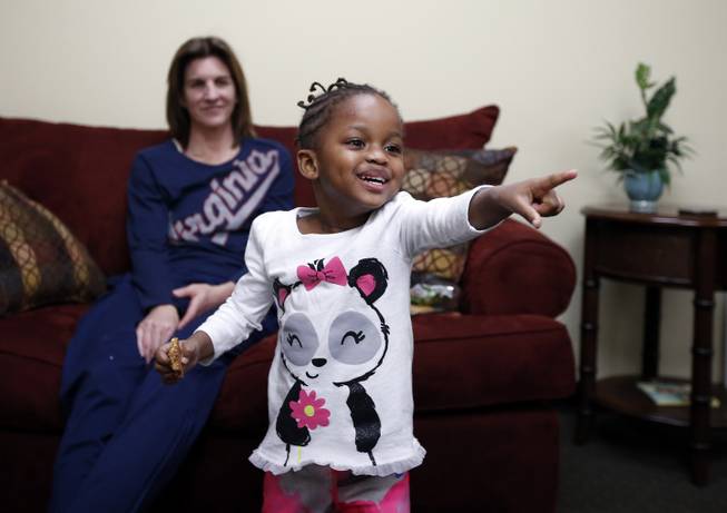 Ngoty plays with her adopted mom, Virginia women's basketball coach Joanne Boyle, in Charlottesville, Va., on Jan. 27, 2015. 