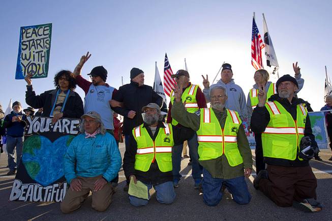 Protesters wait to be arrested after crossing a line onto base property during an anti-drone protest at Creech Air Force Base, about 50 miles northwest of Las Vegas, March 6, 2015. About 100 people came out for the protest organized by the peace group CODEPINK. .