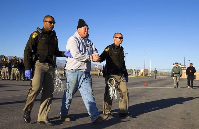 A protester is  arrested after crossing a line onto base property during an anti-drone protest at Creech Air Force Base, about 50 miles northwest of Las Vegas, March 6, 2015. About 100 people came out for the protest organized by the peace group CODEPINK. AP/Las Vegas Sun/Steve Marcus)..