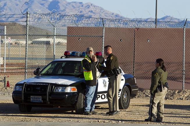 A protester is searched by a Las Vegas Metro Police officer after being arrested during an anti-drone protest at Creech Air Force Base, about 50 miles northwest of Las Vegas, March 6, 2015. About 100 people came out for the protest organized by the peace group CODEPINK. .