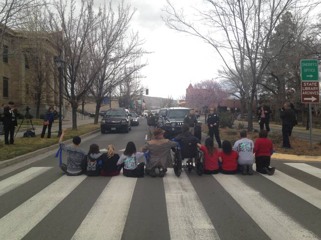 Protesters sit in Carson Street to stop traffic, March 11, 2015. More than 100 protestors stormed the Attorney General's office this morning demanding to speak to Adam Laxalt about a federal lawsuit that has put a hold on immigration reform.