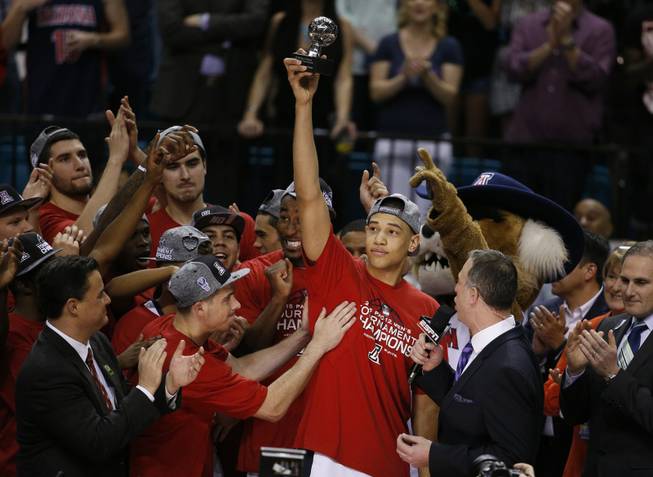 Arizona's Brandon Ashley holds up the most outstanding player of the tournament trophy after Arizona defeated Oregon in an NCAA college basketball game in the championship of the Pac-12 conference tournament Saturday, March 14, 2015, in Las Vegas. 