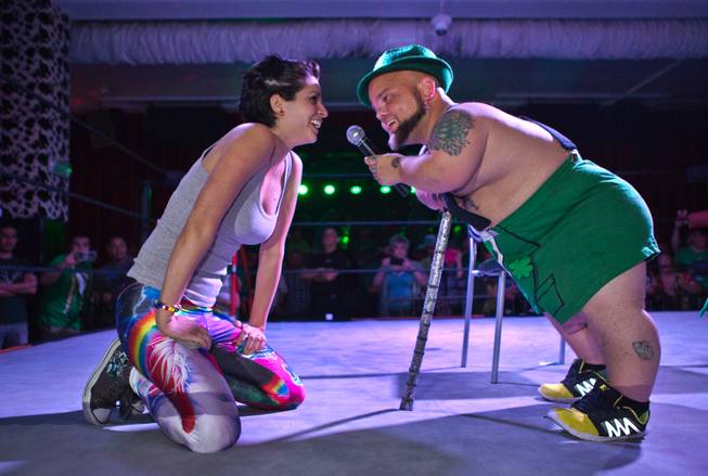 Wrestling fan Erika Morales is questioned by MC Turtle after she bid the highest price to staple money to his scrotum during a stunt in the St. Patricks Day Leprechaun Smackdown by Midgets Unleashed at the Fremont Country Club on Tuesday, March, 17, 2015.