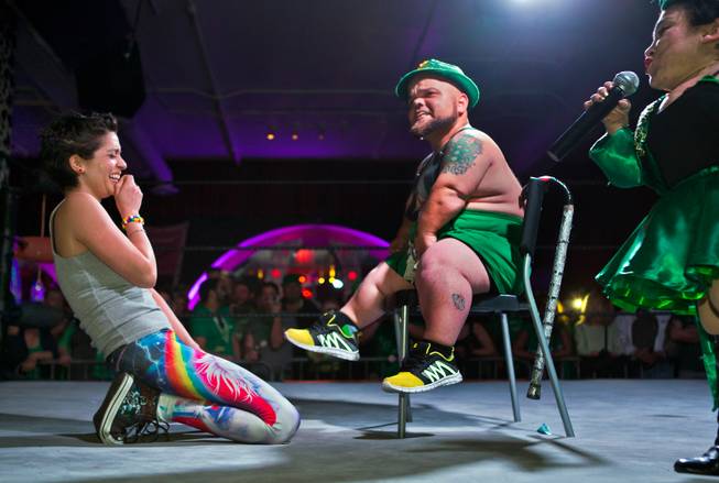 Wrestling fan Erika Morales laughs as MC Turtle plays up the pain after she stapled a bill to his scrotum during a stunt in the St. Patricks Day Leprechaun Smackdown by Midgets Unleashed at the Fremont Country Club on Tuesday, March, 17, 2015.