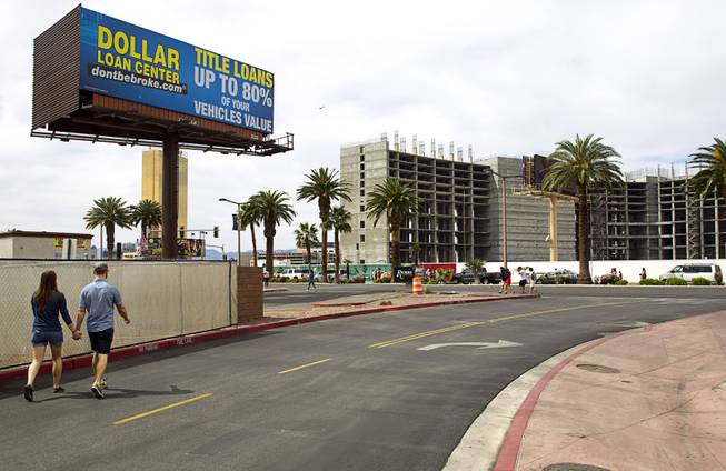 A couple walks toward Las Vegas Boulevard Sunday, March 22, 2015. In the background is the uncompleted Echelon casino project. The Maylasia-based Genting Group bought the site and announced plans for Resorts World Las Vegas in March 2013.