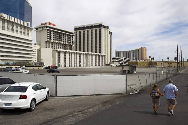 A couple walks by an empty lot owned by development company Triple Five between the  Peppermill Restaurant & Fireside Lounge and the Riviera Sunday, March 22, 2015.