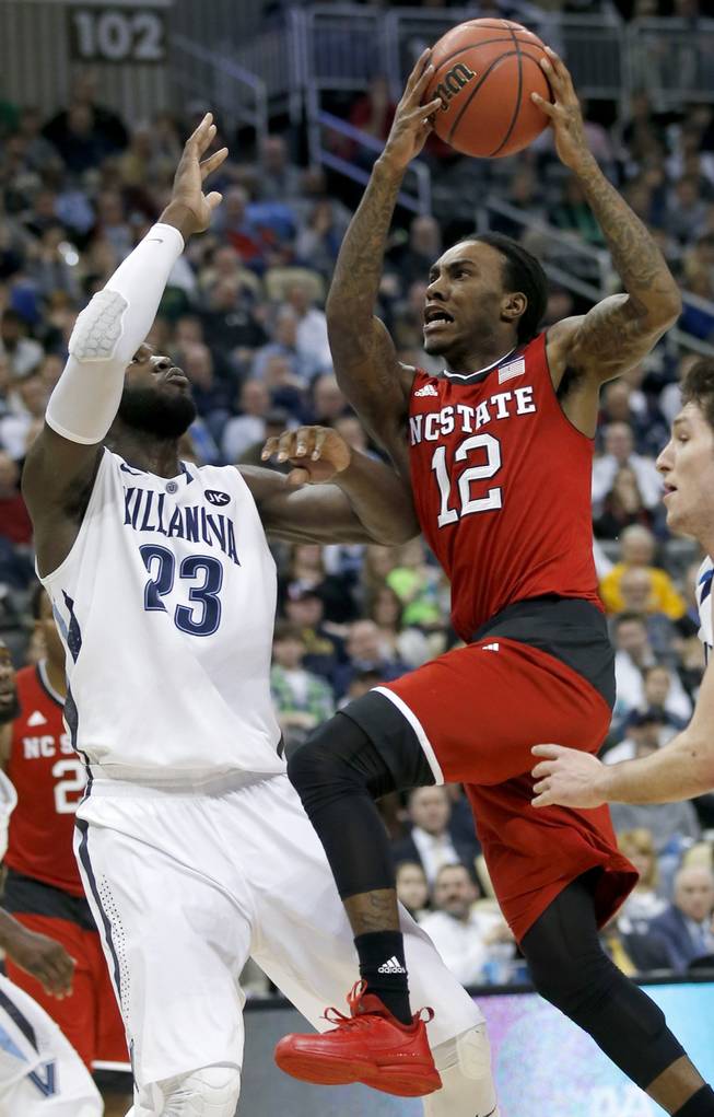 North Carolina State's Anthony Barber, right, shoots in front of Villanova's Daniel Ochefu during the first half of an NCAA tournament third-round college basketball game Saturday, March 21, 2015, in Pittsburgh.