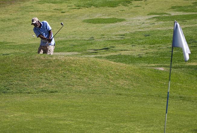 Harold Huddleston hits out of a bunker onto the sixth green at the Municipal Par 3 Golf Course, 324 E Brooks Ave., in North Las Vegas Wednesday, March 25, 2015.