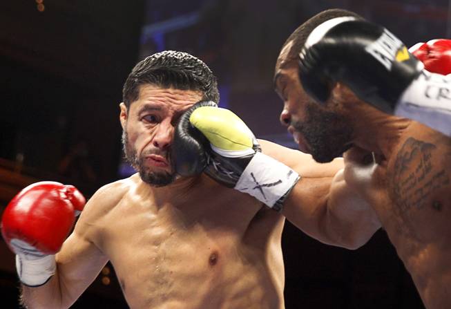 WBC featherweight champion Jhonny Gonzalez, left, of Mexico, takes a punch from Gary Russell Jr. of Washington D.C. during their title fight at the Palms Saturday, March 28, 2015. Russell took the title with a fourth-round TKO.