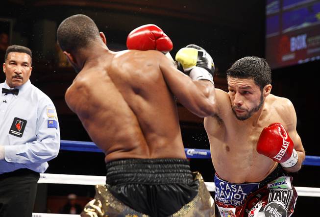 WBC featherweight champion Jhonny Gonzalez, right, of Mexico, punches Gary Russell Jr. of Washington D.C. at the Palms Saturday, March 28, 2015.