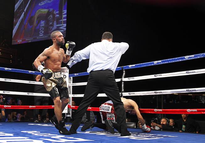 Referee Tony Weeks separates the boxers after WBC featherweight champion Jhonny Gonzalez of Mexico is knocked down in the fourth round by Gary Russell Jr. of Washington D.C. at the Palms Saturday, March 28, 2015. Russell took the title with a fourth-round TKO.