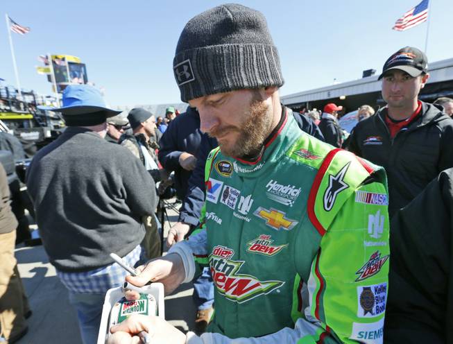 Sprint Cup driver Dale Earnhardt Jr., signs an autograph after practice for Sunday's NASCAR Sprint Cup race at the Martinsville Speedway in Martinsville, Va., on Saturday, March 28, 2015.