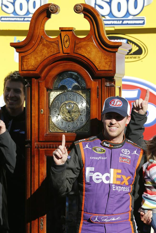 Denny Hamlin poses next to the trophy after the NASCAR Sprint Cup Series auto race at Martinsville Speedway in Martinsville, Va., on Sunday, March 29, 2015. 