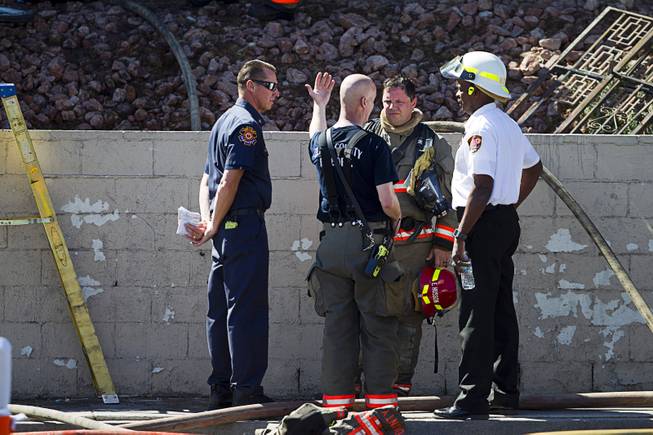 Firefighters confer after a two-alarm apartment fire near Tropicana and Eastern Avenue, March 30, 2015.