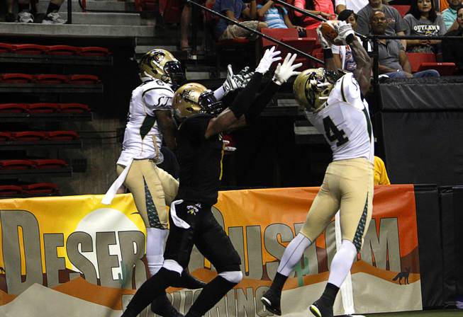 Virgil Gray (4), right, picks off a end zone pass intended for Outlaws' Clinton Solomon (1), center, during the Outlaws' inaugural game against the San Jose SaberCats at the Thomas & Mack Center Monday, March 30, 2015.