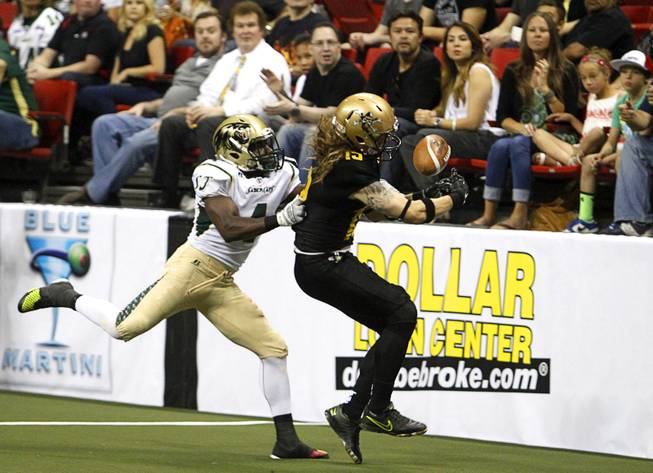 Virgil Gray (4), left, covers Outlaws' Tysson Poots (19) during the Outlaws' inaugural game against the San Jose SaberCats at the Thomas & Mack Center Monday, March 30, 2015.