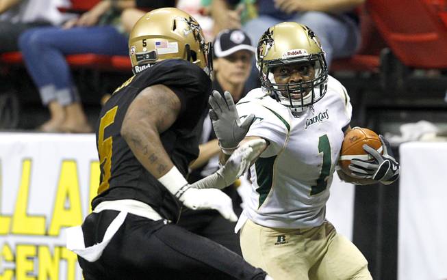 Reggie Gray (1) of the San Jose SaberCats trys to avoid a tackle by Dee Webb (5) of the Las Vegas Outlaws during the Outlaws' inaugural game against the San Jose SaberCats at the Thomas & Mack Center Monday, March 30, 2015.