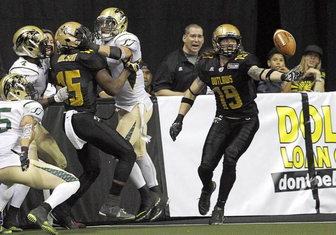 Tysson Poots (19), right, catches a ball knocked loose from Jomo Wilson (15) during the Outlaws' inaugural game against the San Jose SaberCats at the Thomas & Mack Center Monday, March 30, 2015.