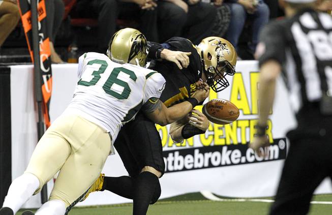 Luis Vasquez (36) forces Outlaws quarterback J.J. Raterink (11) to fumble during the Outlaws' inaugural game against the San Jose SaberCats at the Thomas & Mack Center Monday, March 30, 2015.