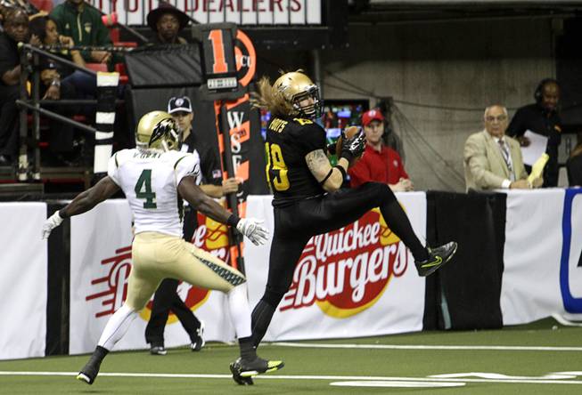 Outlaws' Tysson Poots (19) makes a reception during the Outlaws' inaugural game against the San Jose SaberCats at the Thomas & Mack Center Monday, March 30, 2015. Poots broke a tackle by Virgil Gray (4), left, and ran the ball in for a touchdown.