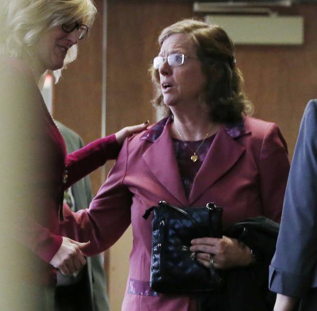 File--In this file photograph taken on Monday, Dec. 8, 2014, an unidentified woman, left, consoles Arlene Holmes, right, as she leaves the courtroom after a pre-trial readiness hearing in Centennial, Colo., in the murder trial of her son, James Holmes, who is charged with killing 12 moviegoers and wounding 70 more in a shooting spree in a crowded theatre in Aurora, Colo., in July 2012. Arlene Holmes and her husband, Bob, told the Del Mar Times in the couple's first interview since the mass shooting about the book she wrote after her son's rampage in which she said that she prays for the victims of the theatre rampage daily "by name and by wound." 
