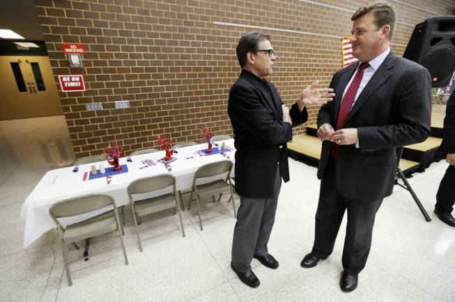 In this July 19, 2014, file photo, then-Texas Gov. Rick Perry, left, talks with Story City pastor Jamie Johnson, who is now working for Perry, during a meeting with local party activists in Algona, Iowa. Iowa pastors have been politically active for many years, and going into 2016, a host of potential candidates are wooing pastors.