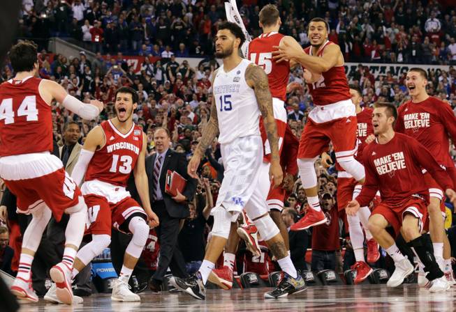 The Wisconsin bench celebrates as Kentucky's Willie Cauley-Stein walks off after the NCAA Final Four tournament semifinal game Saturday, April 4, 2015, in Indianapolis. Wisconsin won 71-64.