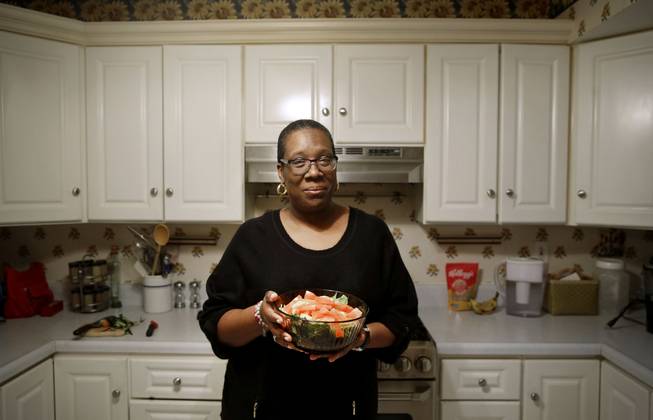In this April 3, 2015, photo, Michele Rouse holds a salad that she made in her kitchen in Edgewood, Md. Rouse says she has lost 7 pounds since she started on Weight Watchers a month ago and has already seen a drop in her elevated blood pressure. Weight Watchers and Jenny Craig scored the best marks for effectiveness in a review of research on commercial diet programs, but many other plans just haven't been studied enough to evaluate long-term results.