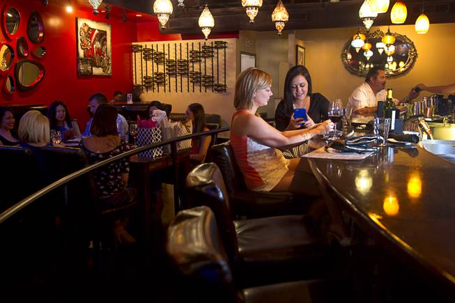 Afton Newson, left, and Jessica Kempany try some wine at the bar in the Double Helix Wine & Whiskey Lounge in Town Square Sunday, April 12, 2015.   .