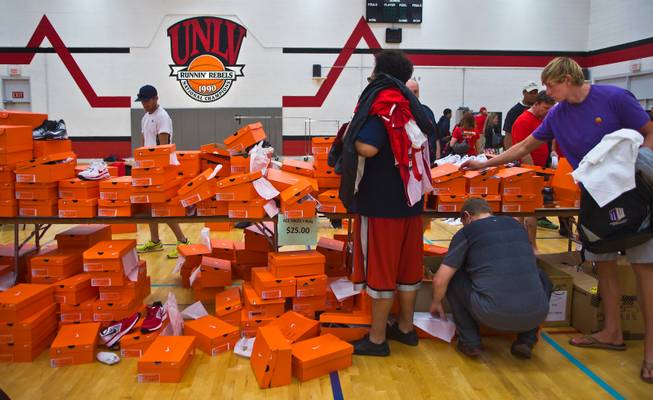 Fans comb through tables of athletic shoes at the UNLV rummage sale before the start of the football Spring Showcase, the last official gathering for the Rebels and coach Tony Sanchez before August on Saturday, April 18, 2015.