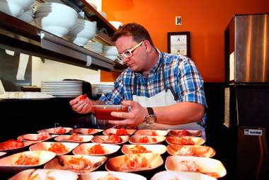 Brian Howard, chef/owner of the Grazing Pig Food Group, helps to prepare a chef’s dish during the Sunday Night Supper Series at MTO featuring a Korean Brasserie on Sunday, April 19, 2015.