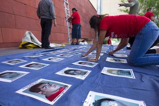 Organizers pin photos of missing students onto a banner as they prepare for a 