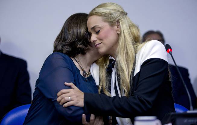 Mitzy Capriles de Ledezma, left, wife of imprisoned Caracas Mayor Antonio Ledezma, and Lilian Tintori, wife of jailed opposition leader Leopoldo Lopez, hug during a meeting with lawmakers in the Argentine Congress in Buenos Aires, Argentina, Friday, March 27, 2015. Leopoldo Lopez and Antonio Ledezma are Venezuela's most-prominent anti-government prisoners. 